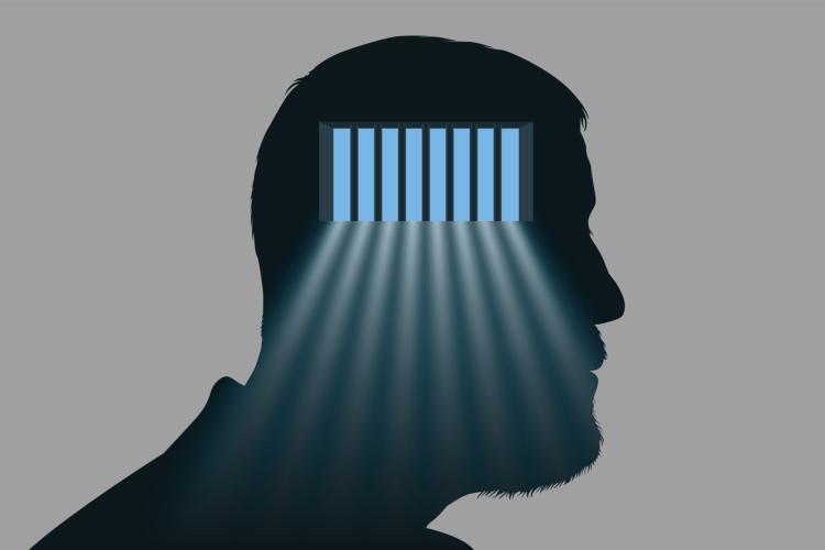 Silhouette of man with bars shining through head