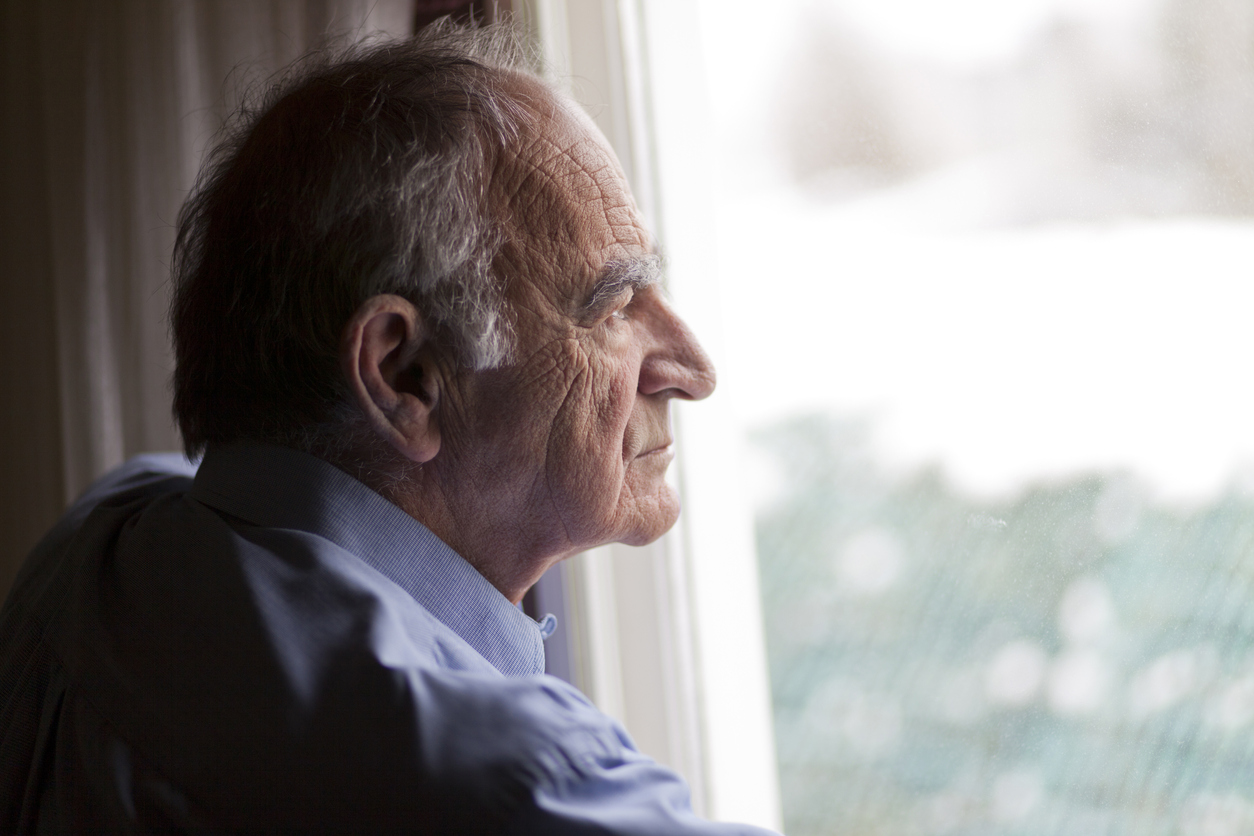 Older man staring out window