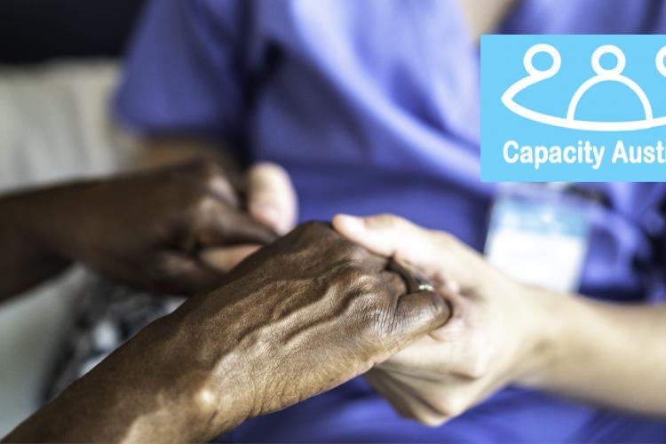 Capacity Australia logo over picture of nurse holding woman's hands