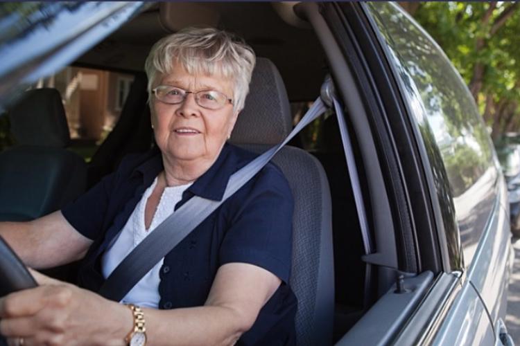 Older woman driving car smiling