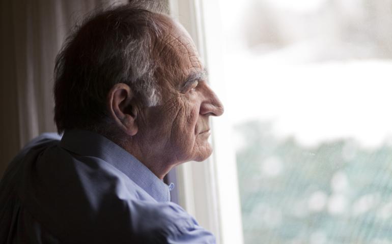Older man staring out window